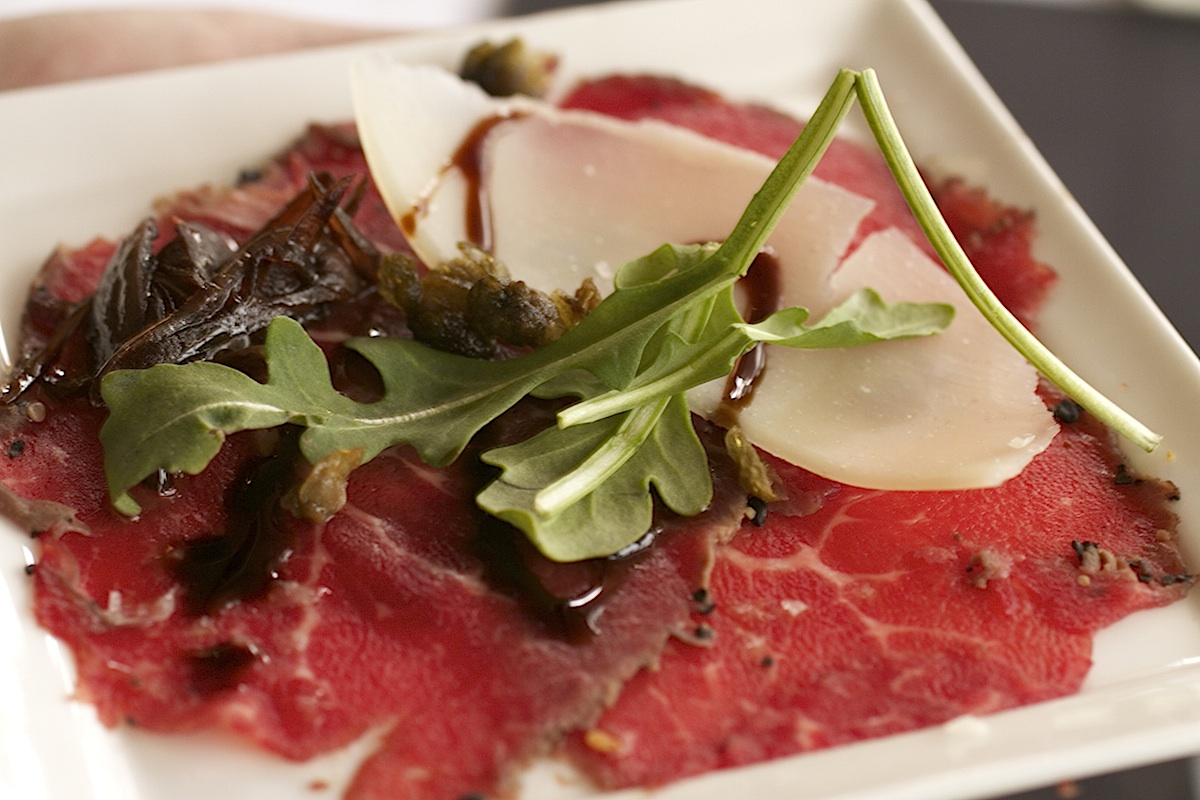 NZ Beef Tenderloin Carpaccio with Baby Arugula, Aged Parmesan, Balsamic Shallots and Crispy Capers 